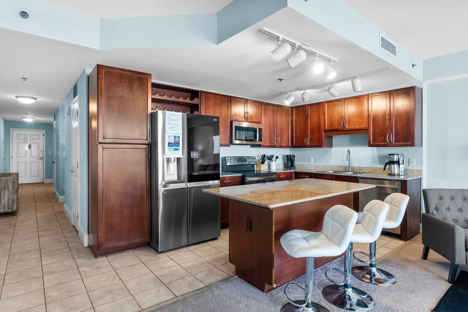 Modern kitchen with stainless steel appliances and a central island with seating.