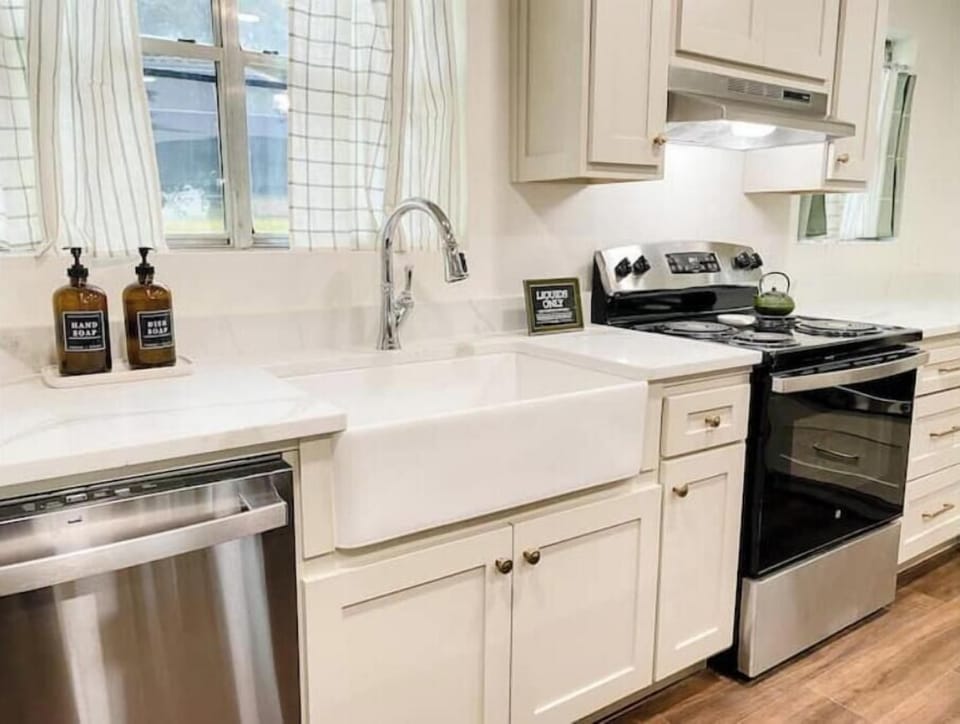 Dishwasher, farmhouse sink, four burner stove with oven
