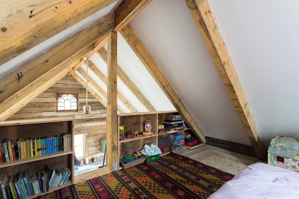The loft bedroom is stocked with vintage board games, toys, books, and a dollhouse 