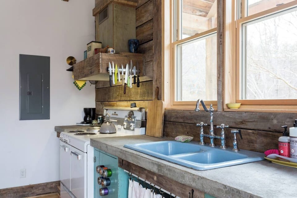 The hand-poured concrete countertops, blue sink, and vintage stove make for a fun space to cook.