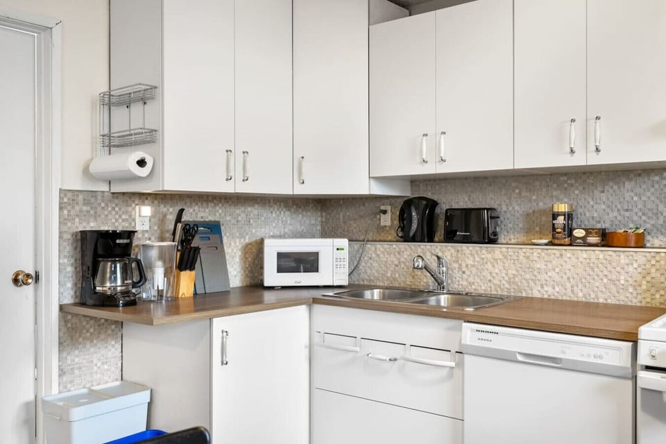Complete kitchen with white cabinets, wood counters, and modern appliances