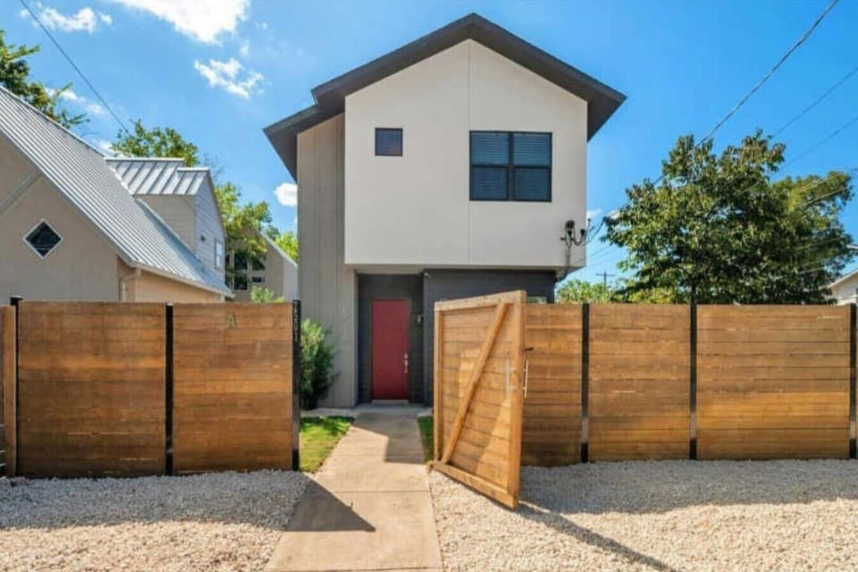 Welcome to your stylish home away from home! This modern entrance with a bold red door sets the tone for a unique and inviting stay.