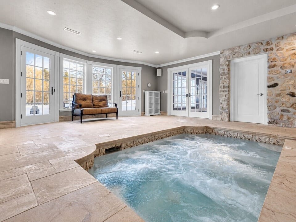 The oversized 14-person hot tub sits inside the private, year-round pool wing.