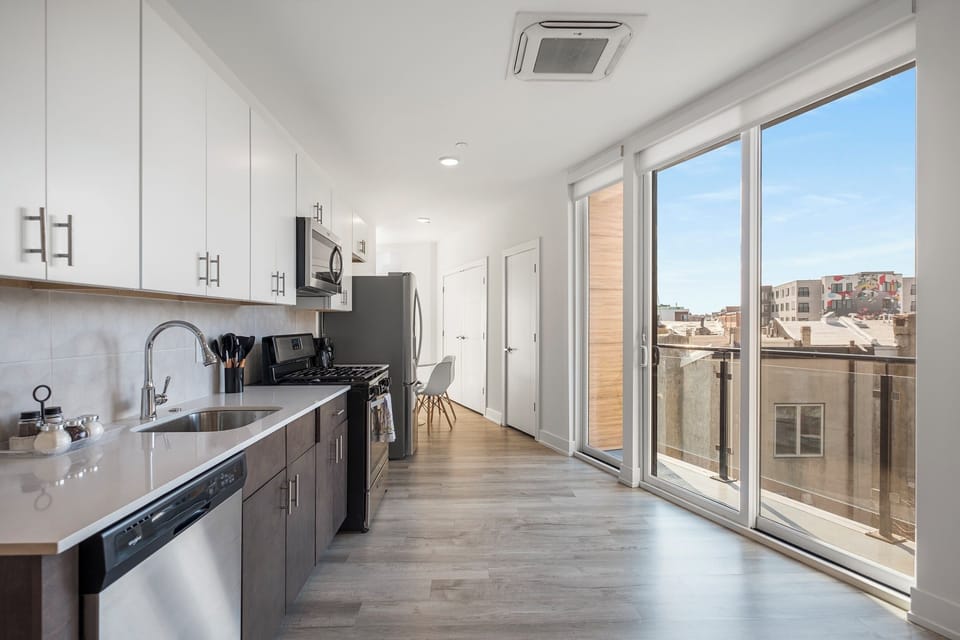 Kitchen with windows, cherry cabinetry, and island seating offering functional workspace.