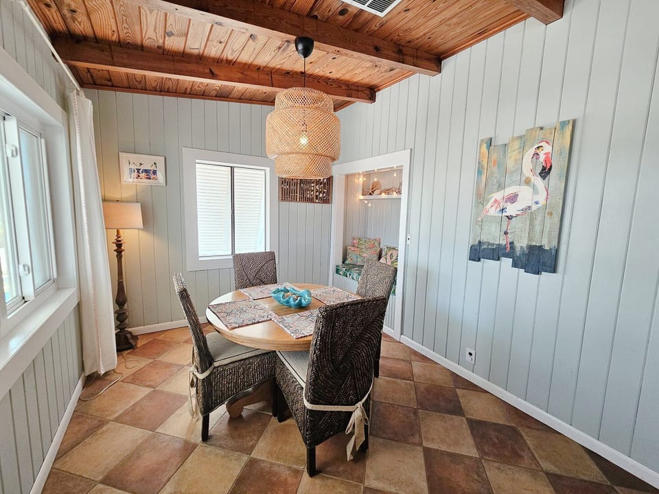 The chic coastal ambience of the home is echoed in the dining area where a simple table setting for four combined with elegant, soft lighting and whimsical décor create a cheerful, inviting atmosphere for sharing meals with loved ones.