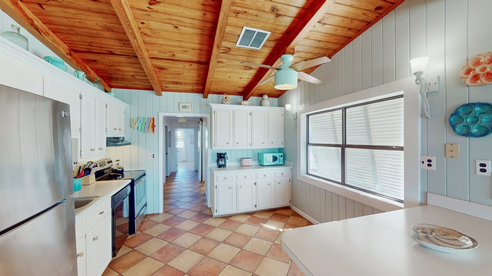 The open kitchen, fully equipped to cater to your culinary needs, overlooks the living area, ensuring you're never far from the conversation. It's a delightful space for preparing meals and gathering as a family.