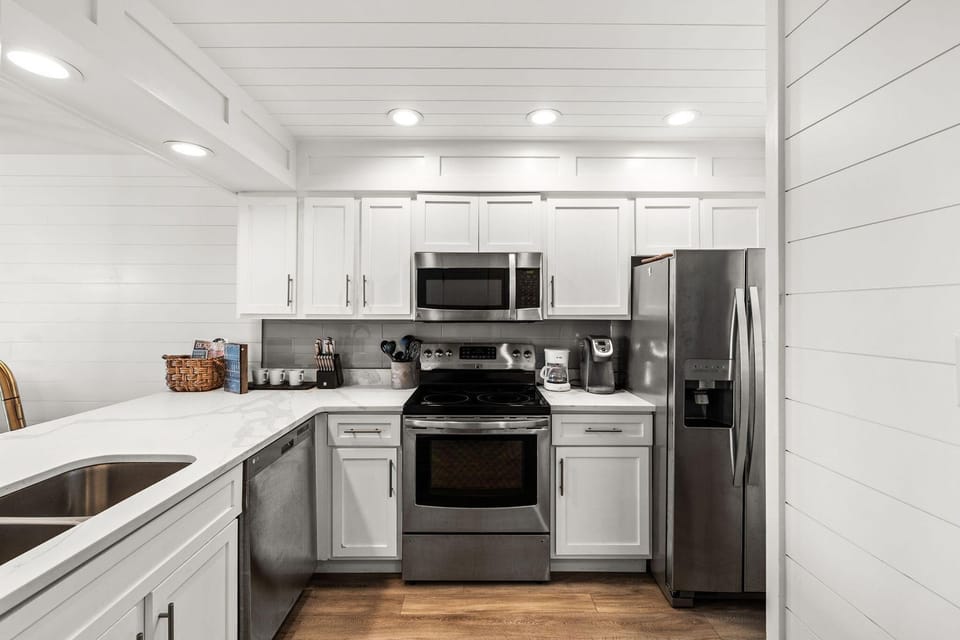 Your fully-equipped kitchen features crisp white cabinets, stainless steel appliances, and everything you need to create memorable meals during your stay.