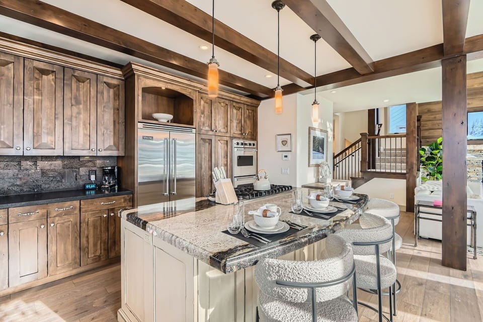 Gourmet kitchen with granite countertops, large island bar, and stainless steel appliances. Perfect for preparing group meals during your mountain escape.