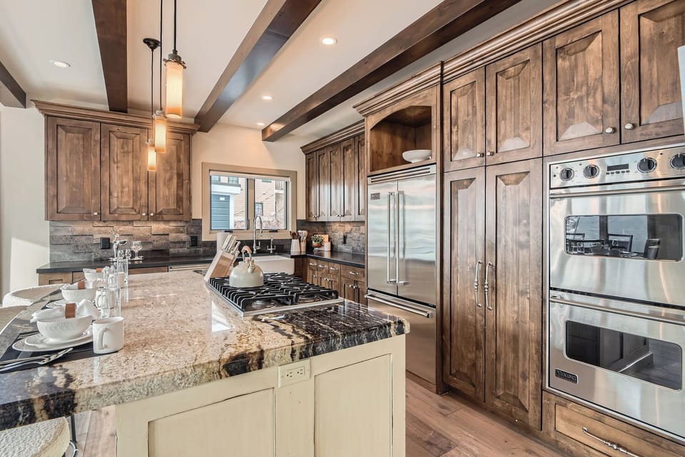 Gourmet kitchen with granite countertops, large island bar, and stainless steel appliances. Perfect for preparing group meals during your mountain escape.