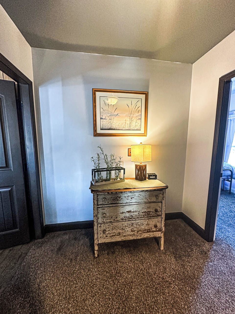 Elegant Hallway Nook – A beautifully decorated hallway area with a vintage-style dresser and warm lighting, adding a touch of character and charm to the home.

