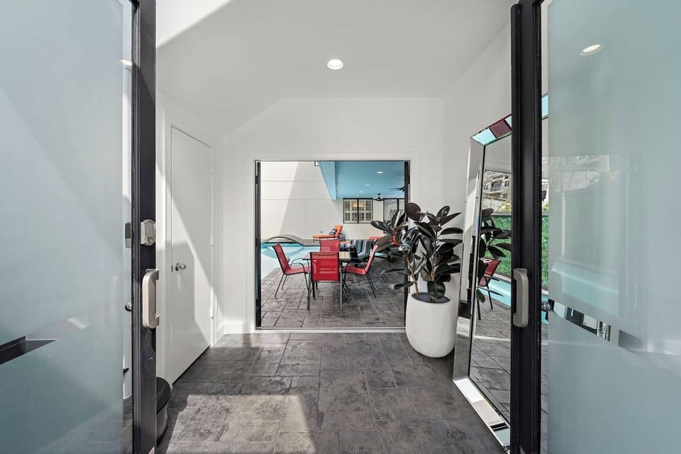 Step into a light-filled front entry that seamlessly flows either through to the backyard and pool oasis or up the rounded staircase. This entire space is bathed in natural light from large windows.