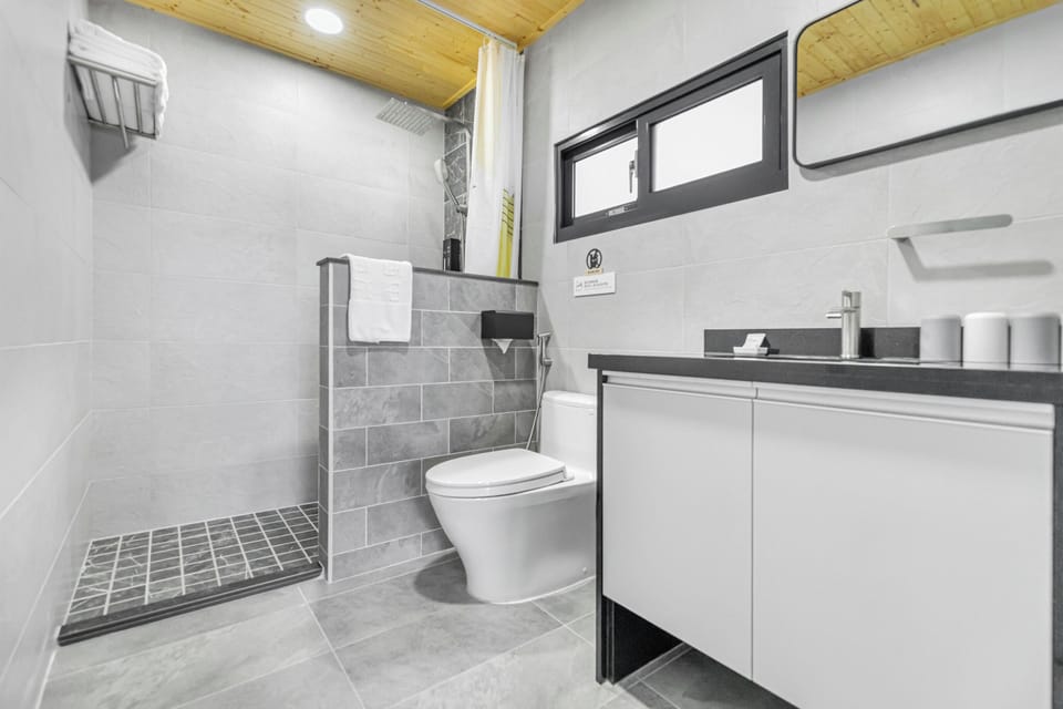 Deluxe Quadruple Room, Balcony | Bathroom | Shower, hair dryer, slippers, towels