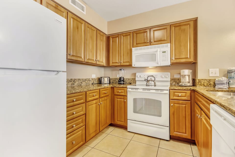 Your fully equipped kitchen features warm wood cabinetry, granite countertops, and all the appliances you need for preparing meals during your stay.