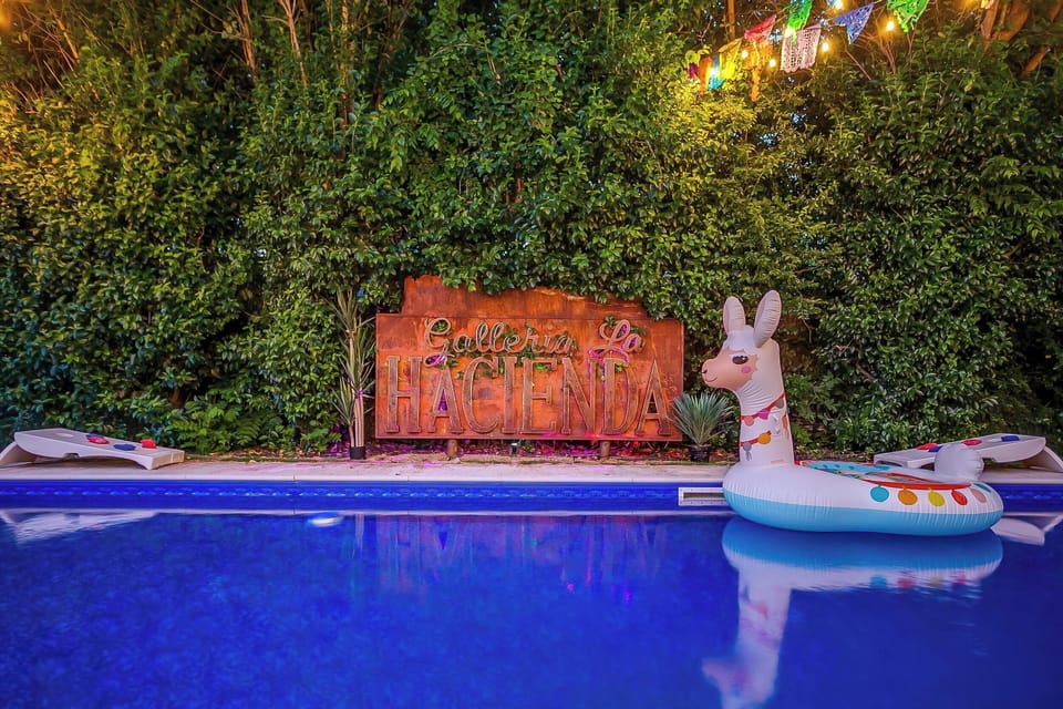 Hacienda after dark. Pool glowing, lights on.