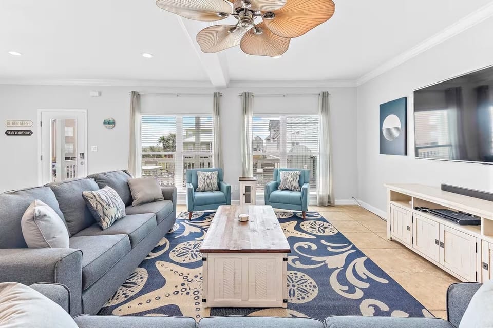 Bright, stylish living room with cozy seating, smart TV, and a cozy vibe
