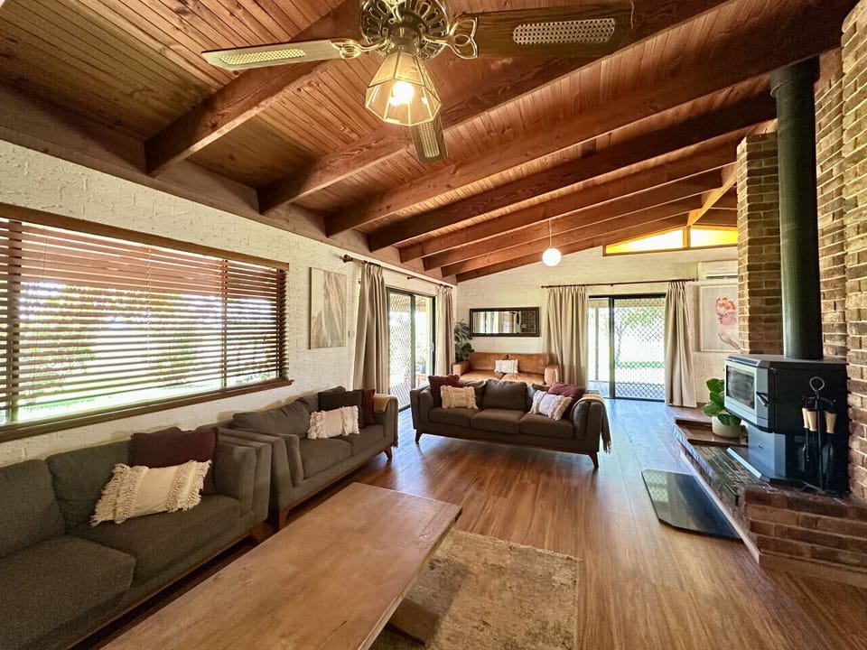 Main house lounge room with fire place, Tv, ceiling fan, air-conditioning