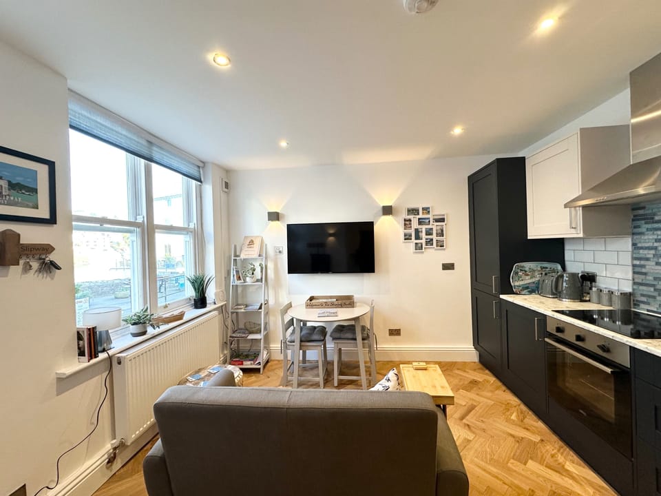 Open plan living room, dining table for 2 and kitchen.