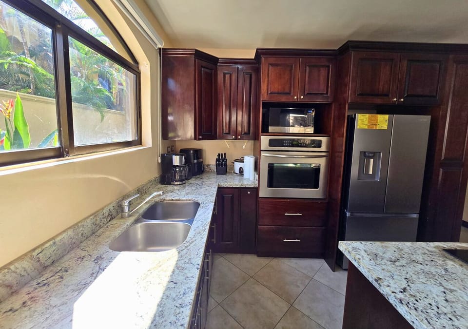 Granite kitchen with stainless appliances and peaceful garden views.