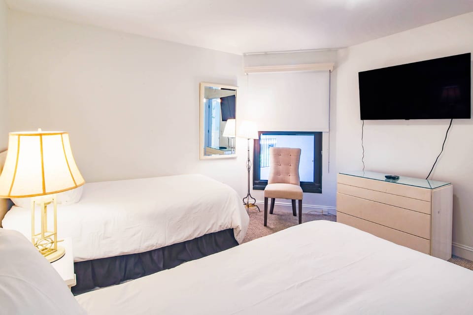 There is a wall-mounted smart TV and dresser in the guest bedroom.