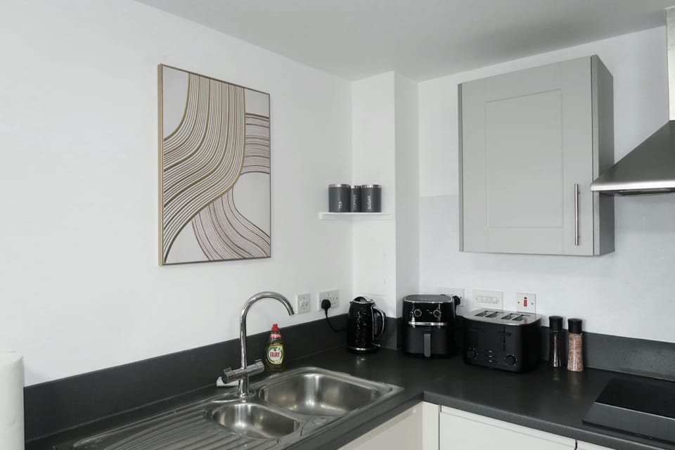 Modern kitchen with cookware and utensils.