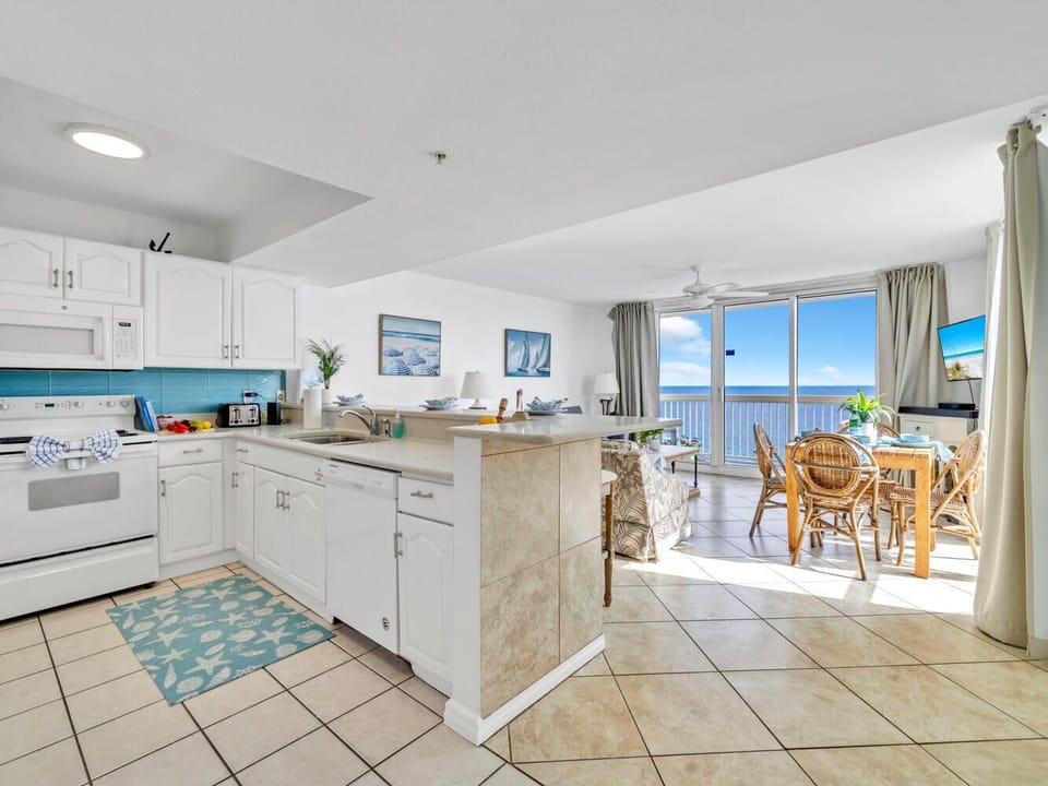 Your bright kitchen and dining area where you'll prepare meals while gazing at endless blue waters through floor-to-ceiling windows.