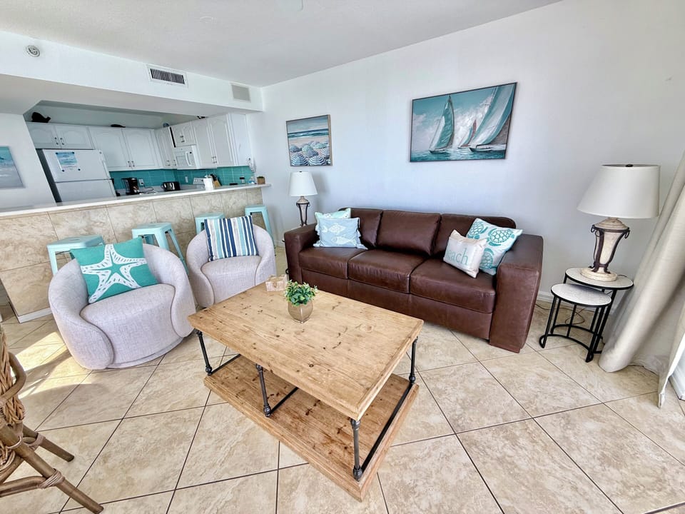 Settle into your coastal-inspired living space where nautical artwork and beach hues create a relaxing atmosphere perfect for unwinding after beach days.