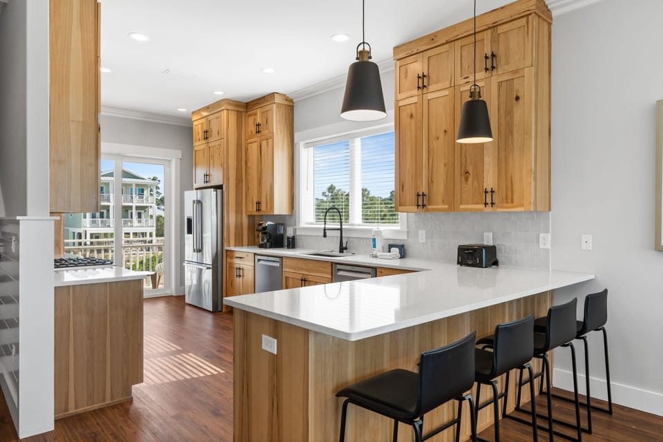 Your gourmet kitchen features warm wood cabinetry, quartz counters, and a spacious island where you'll love preparing meals and gathering.