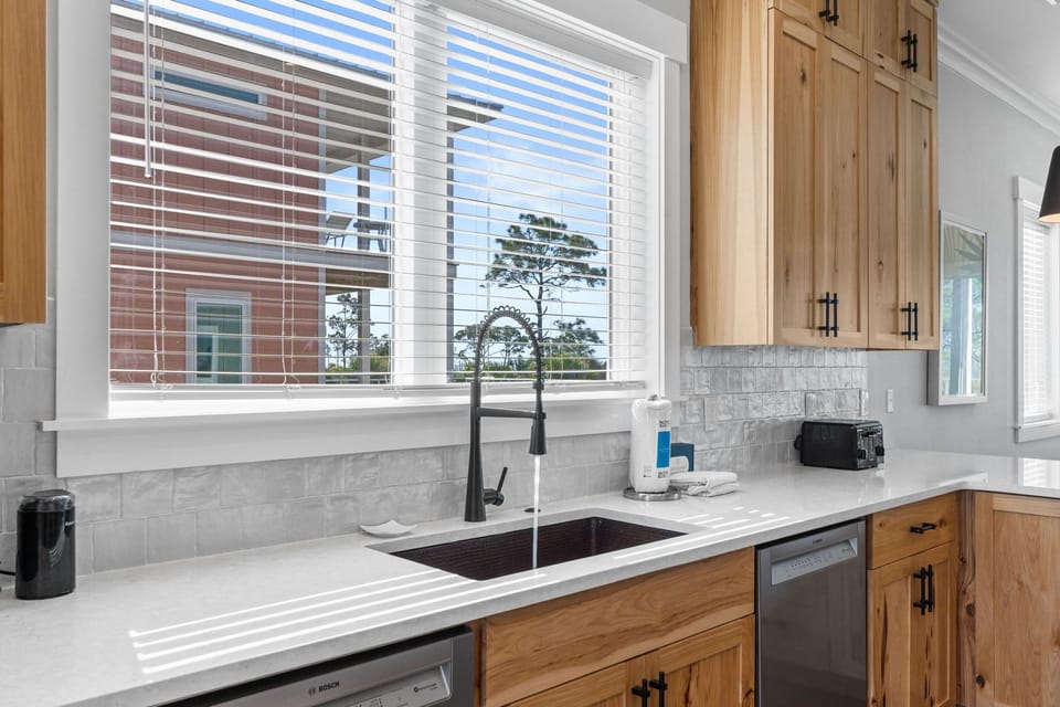 Your fully equipped kitchen features beautiful wood cabinetry, quartz countertops, and modern appliances for preparing memorable meals during your stay.
