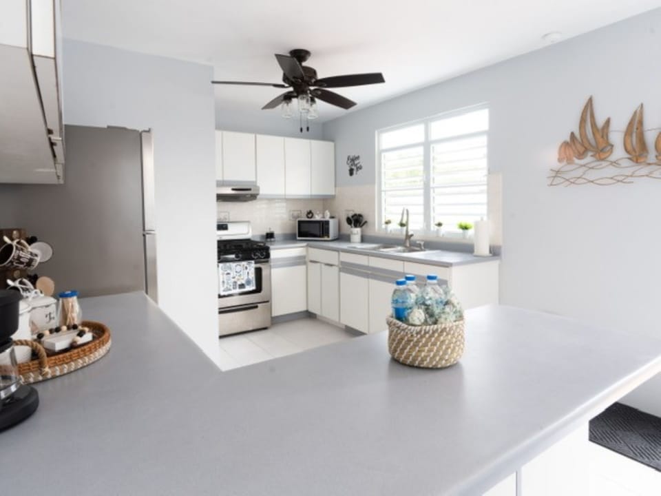 Fully equipped kitchen with pots, dishes, wine glasses, and more.