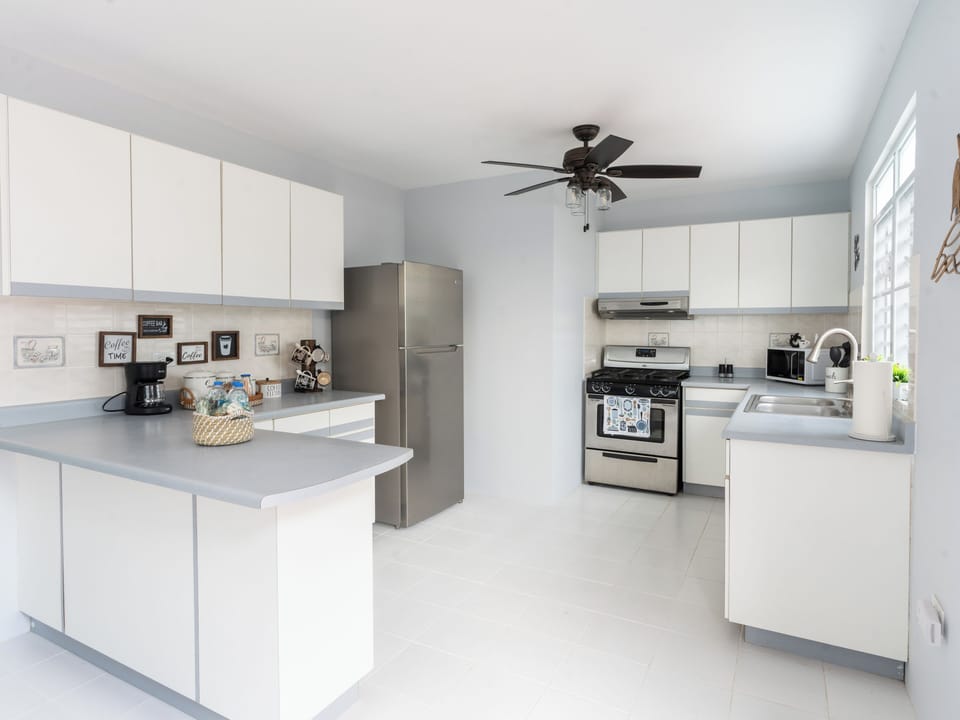 Fully equipped kitchen with pots, dishes, wine glasses, and more.