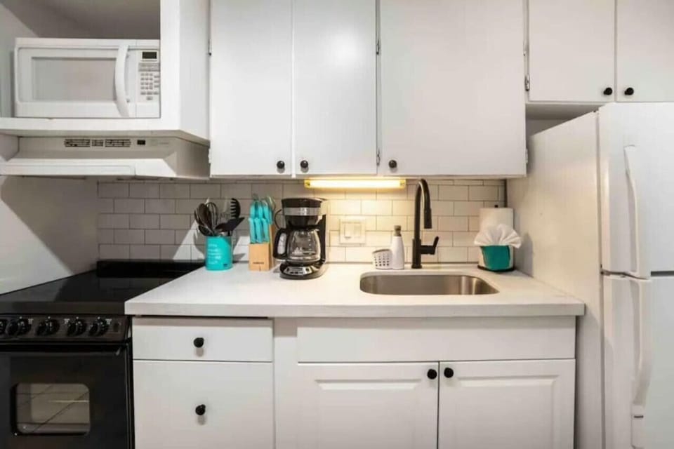 Fully Equipped Kitchenette ☕  This bright, efficient space features a crisp subway tile backsplash and all the essentials—including a coffee maker, microwave, and full stove—for easy vacation meals.