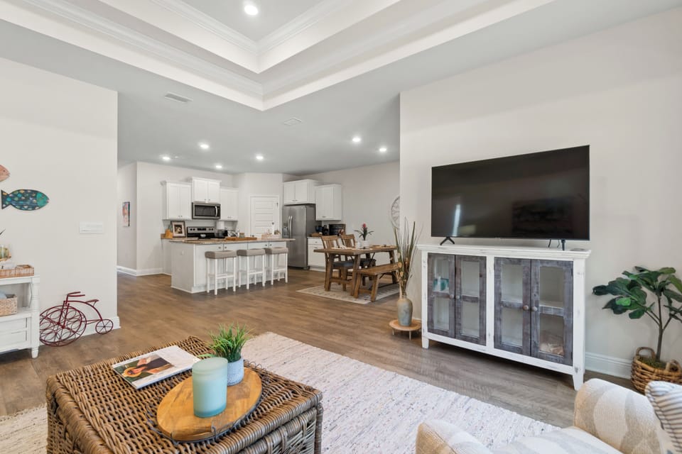 Relax in your spacious open-concept living area where coastal charm meets modern comfort, complete with a fully equipped kitchen.