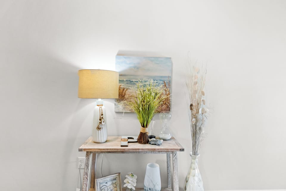 Unwind in this thoughtfully styled space where coastal artwork and warm lighting create your perfect retreat atmosphere.