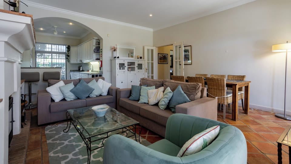 Bright south facing living room with table seating 6 and kitchen off