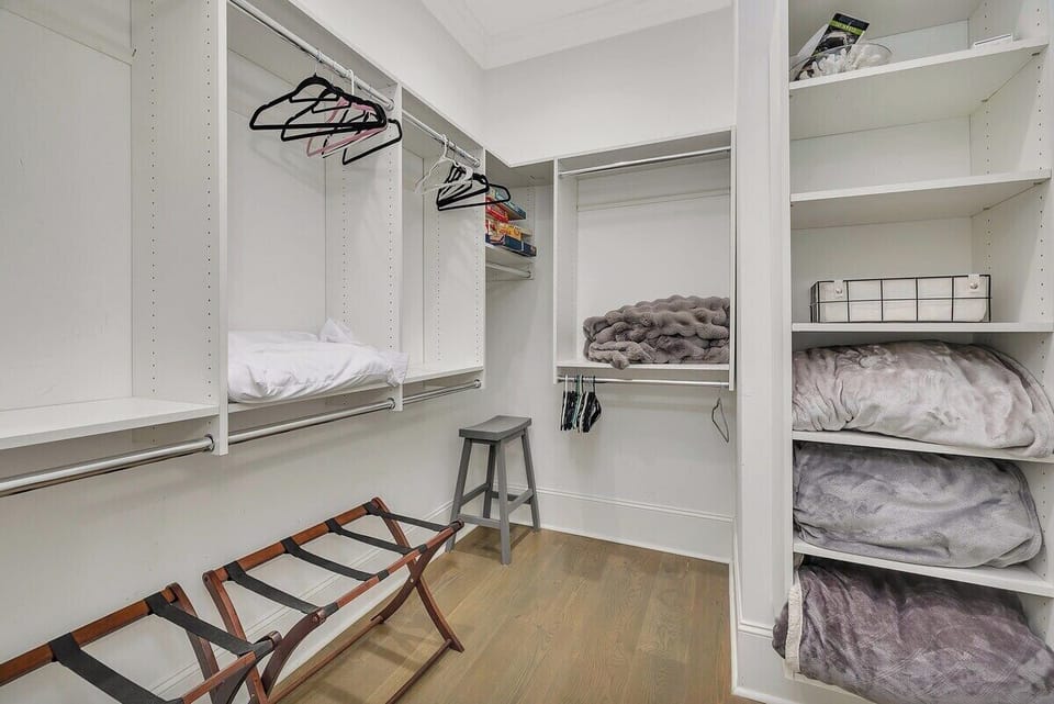 Walk-in closet with built-in shelving and luggage rack
