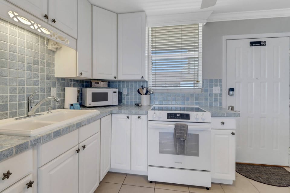 Cookware, dinnerware, many kitchen tools and small appliances are provided, including a drip coffee maker.
