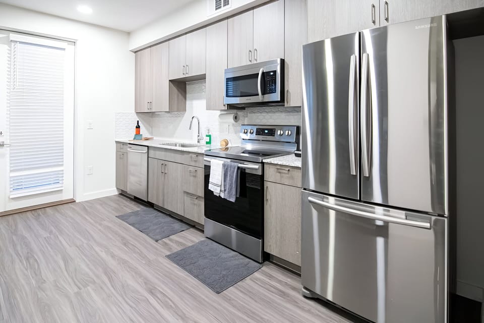 Sleek and modern kitchen with stainless steel appliances and ample counter space. Perfect for preparing meals and enjoying time together.