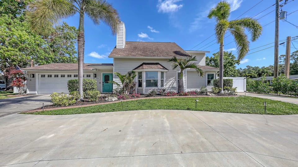 Pull into paradise with plenty of parking, a teal front door, and a cheerful welcome home.