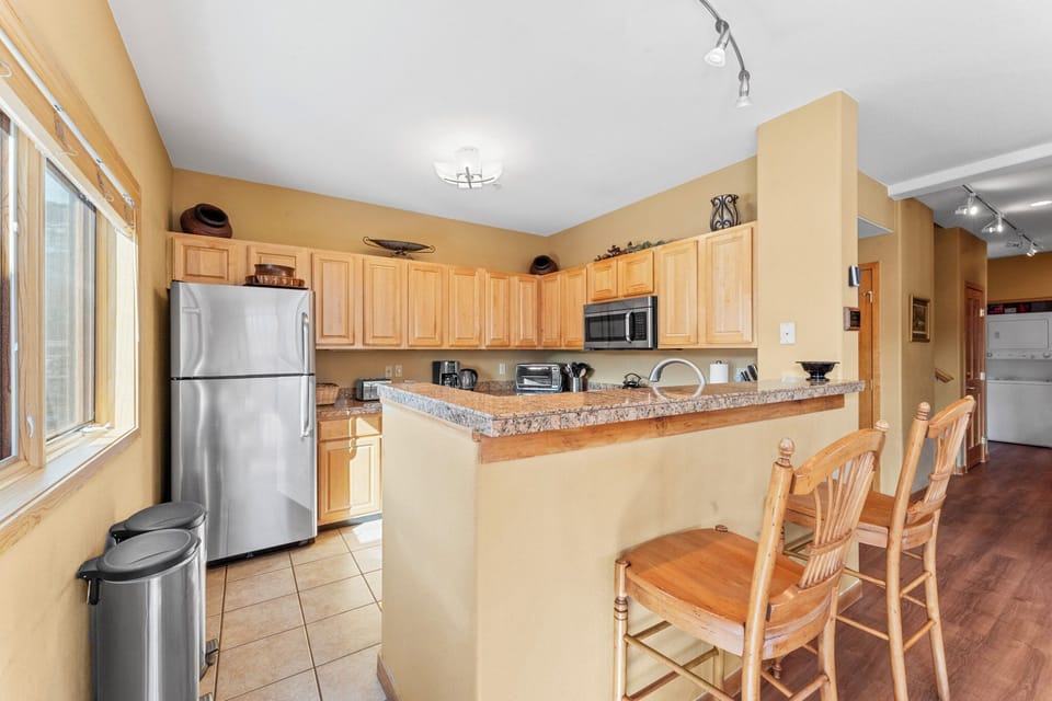 Full kitchen with stainless steel appliances, and breakfast bar seating 2 for casual dining.