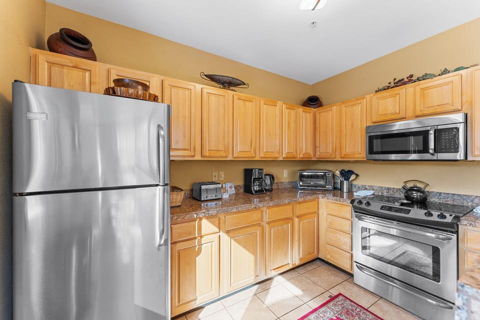 Full kitchen with stainless steel appliances, and breakfast bar seating 2 for casual dining.