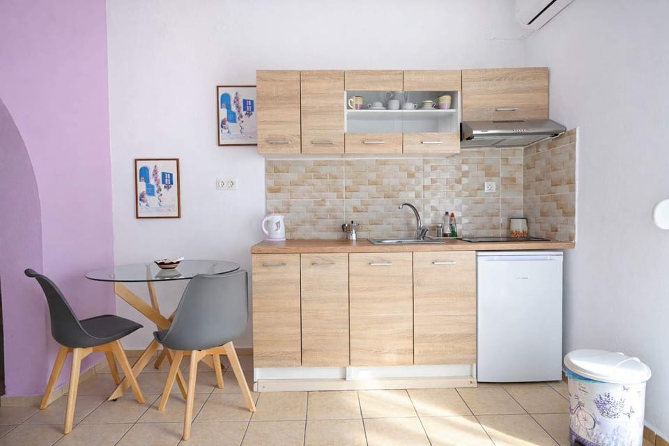 Kitchen Space – Equipped with Wooden Cabinets, Sink, and Dining Table