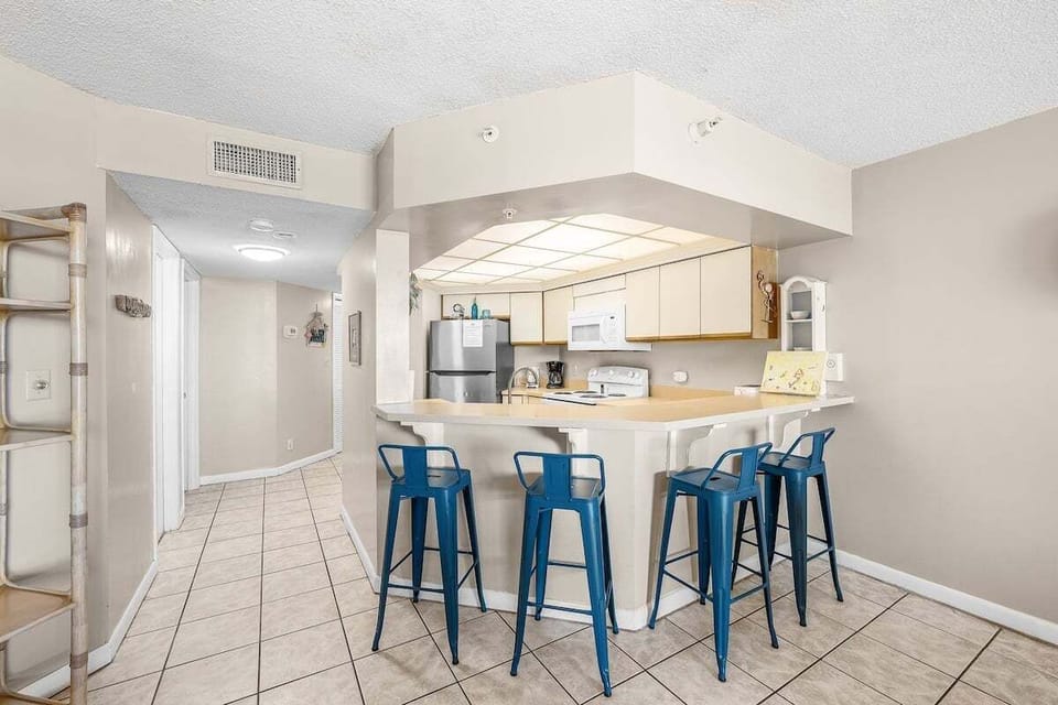 An inviting additional seating area wraps around the kitchen peninsula, perfect for casual meals, morning coffee, or gathering with guests while cooking.