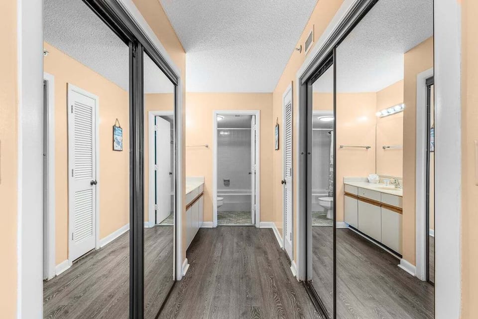 The primary bathroom offers two spacious closets, a combination shower and tub, and plenty of cabinet storage, providing both assessibility and practicality for your daily routine.