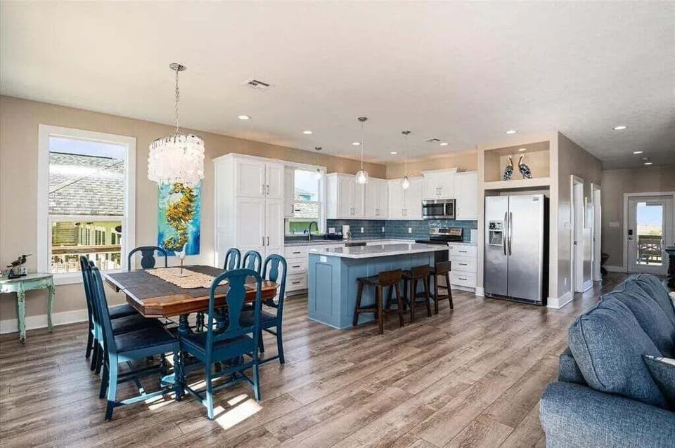 Dining area with large table near kitchen island in Crystal Beach TX beach house rental