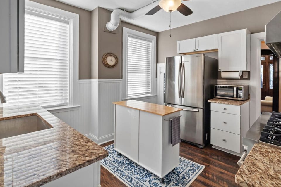 Function Meets Flow – Dual windows flood the space with light while a central island offers extra workspace or a cozy breakfast perch on busy mornings.
