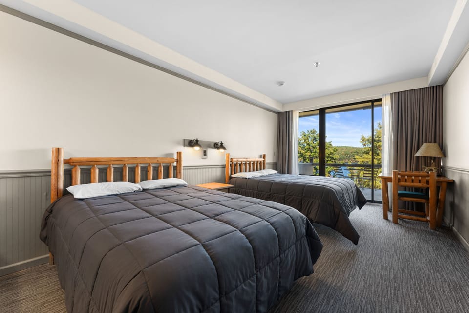 Cozy double queen room with a lake view, perfect for a relaxing retreat after a day of outdoor adventures.