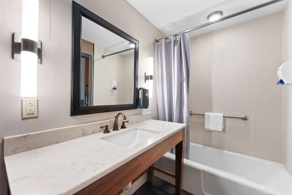Spacious bathroom with a full vanity and bathtub, offering comfort and convenience.