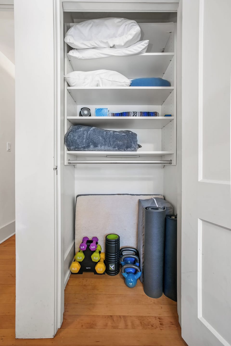 The master bedroom closet is stocked with extra blankets, pillows, a small fan, dog bed and a variety of workout equipment including a set of weights, kettle bells, foam roller, two yoga mats and pack n' play for infants.