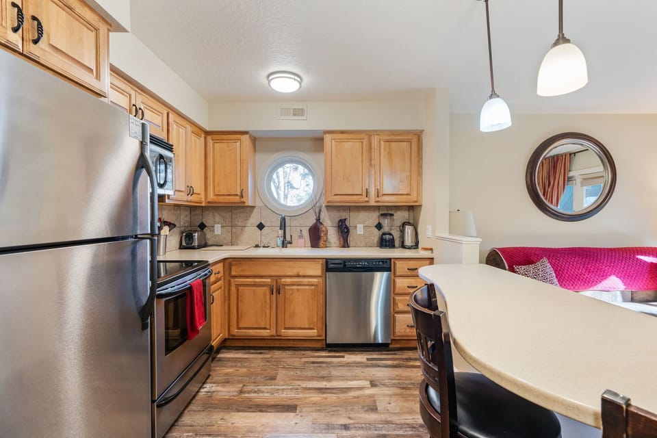 The kitchen features stainless steel appliances, including a microwave, stove, and spacious refrigerator.