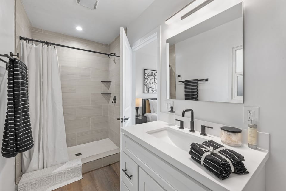 This stunning renovated bathroom boasts a walk-in shower, complete with a vanity with ideal lighting to elevate your morning routines